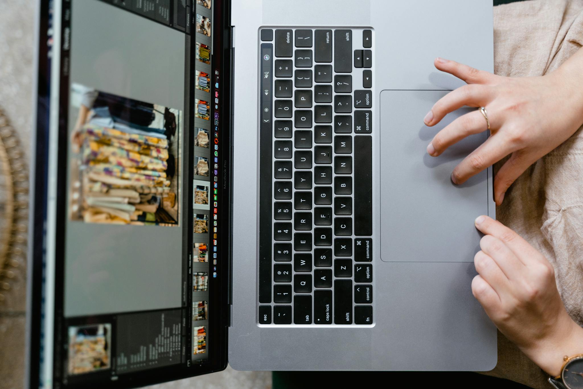 Close-up of hands using a laptop for photo editing, showcasing creativity in digital media.